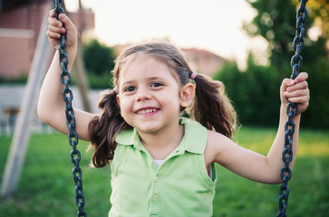 Little girl swinging close up portrait.