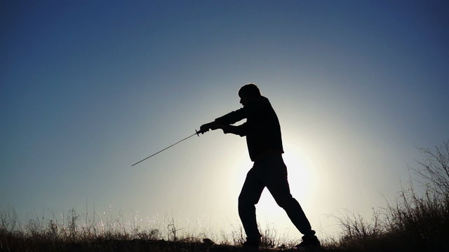 Silhouette of Guy Practicing With Sword