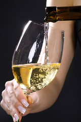 Weißwein Einschank mit Frauenhand Nahaufnahme