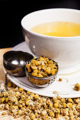 Chamomile tea in a cup of hot water with strainer 
