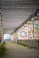 Camino de tierra con grafiiti en las columnas