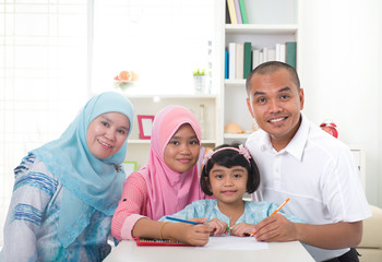 Obraz premium indonesian malay family doing homework together, quality time