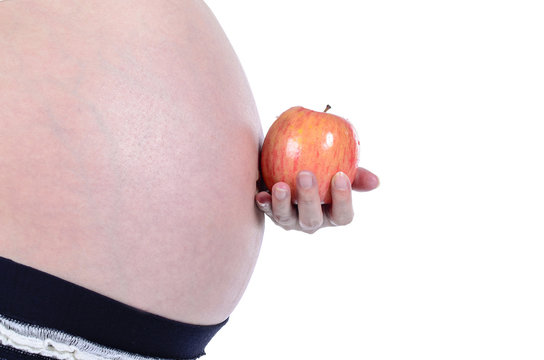 Pregnant woman holding apple  isolated over white background