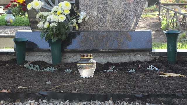 candle glass pot burn flowers near grave cemetery graveyard