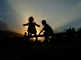 Naklejka na ściany i meble Kinder spielen im Sonnenuntergang / playing children at sunset