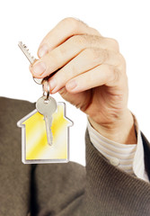 Keys with keychain in the form of a house in a male arm