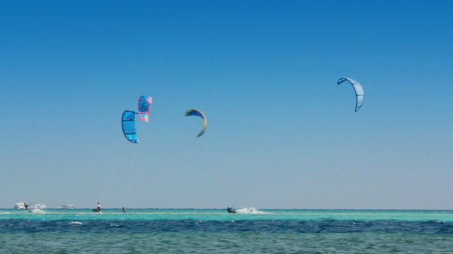 kite surfing - surfers on blue sea surface