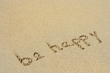 Be happy handwritten in sand