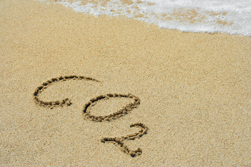 CO2 handwritten in sand on a beach