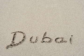 Conceptual handwritten text Dubai in sand