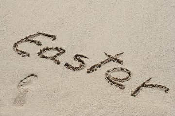 Conceptual handwritten text Easter in sand