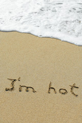 Conceptual handwritten I`m hot text in sand