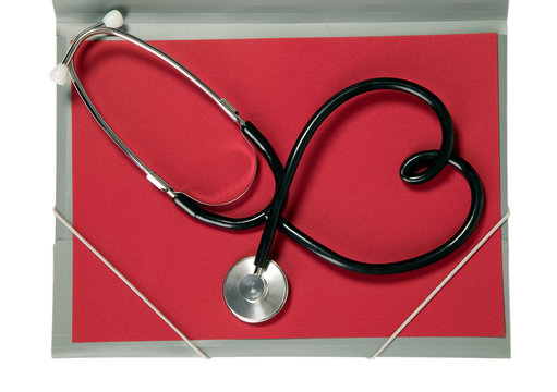 Stethoscope with heart shape is lying on paper