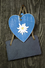 Blaues Holzherz mit Schiefertafel auf Holz