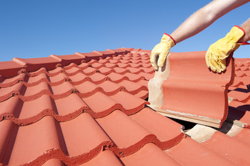 Construction worker tile roofing repair house