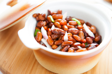 boiled beans in a pot on a wooden surface