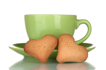 Green cup and saucer with heart-shaped cookies isolated on