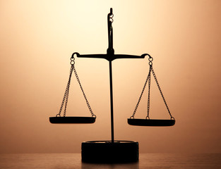 Gold scales of justice on brown background