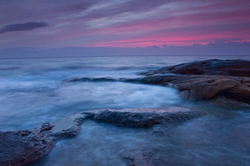 Fototapeta na wymiar Sunrise over the rocky seashore