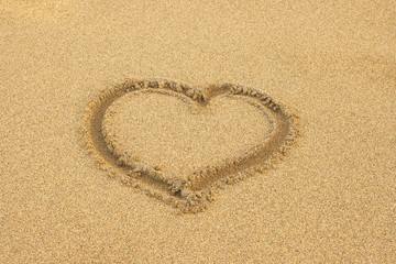 heart drawn in the sand of a beach