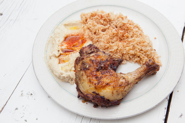 Roasted marinated chicken with saffron rice and hummus