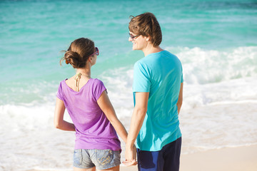 young happy couple having fun on tropical beach. honeymoon