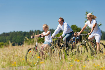 Family cycling outdoors in summer