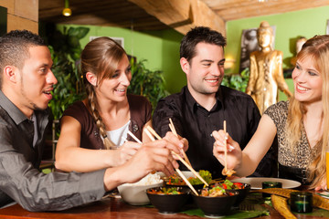Young people eating in Thai restaurant