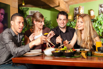 Young people eating in Thai restaurant