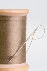 Spool of brown threas with a needle