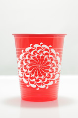 Red color plastic cup with geometric flower draw