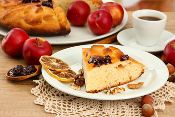 slice of tasty homemade pie with jam and apples and cup of