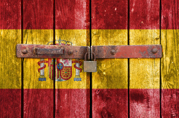 Spain flag on the background of old locked doors