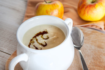 Celery apple vegetable cream soup in white bowl