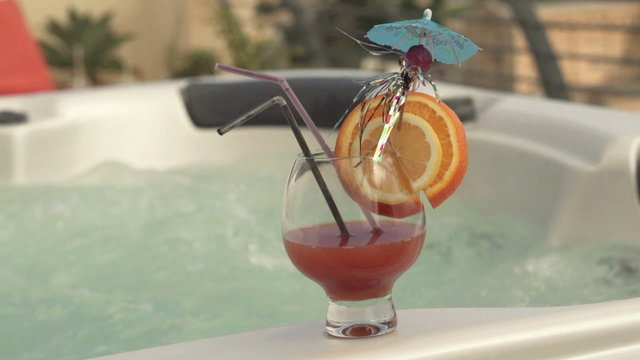 Tasty alcohol cocktail by the hot tub, super slow motion