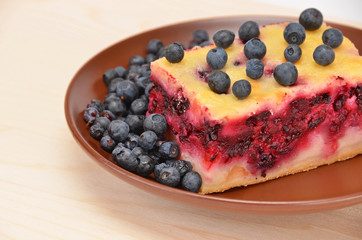 Blueberry pie in on brown plate on wooden background