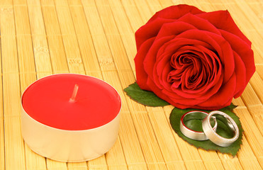 Fototapeta na wymiar róża z obrączki i czerwona świeca