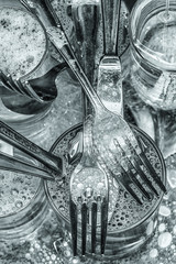 Cutlery being washed with water and detergent © kmiragaya