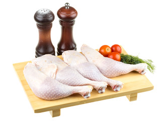 Fresh raw chicken wings on chopping board with roma tomatoes
