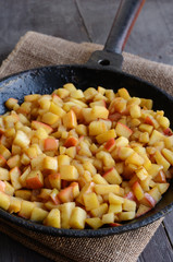 Stewed apples with cinnamon on iron pan