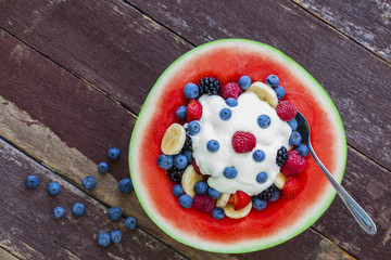 Fruit salad topped with yogurt in carved watermelon