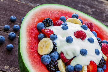 Fruit salad topped with yogurt in carved watermelon