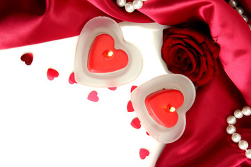 Beautiful candles and rose on red silk background