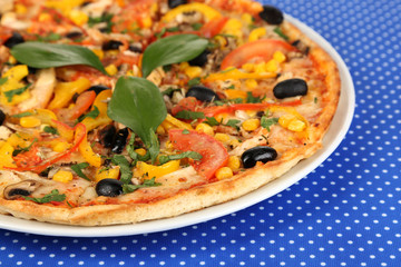 Tasty pizza on blue tablecloth close-up