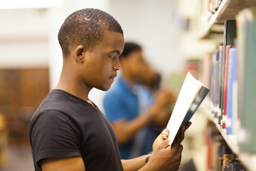 male african college student reading in library