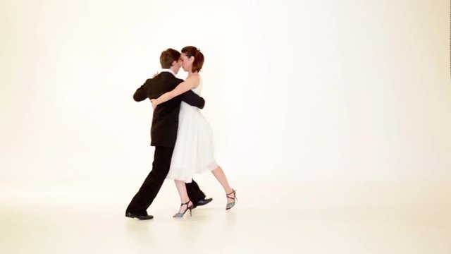 passionate, young couple showing dance moves on white background