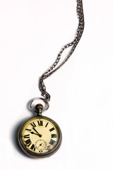 Close up photo of an old pocket watch against white background