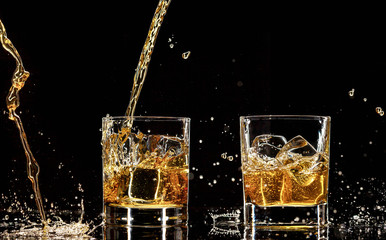 Alcohol drinks with splashes, isolated on black background