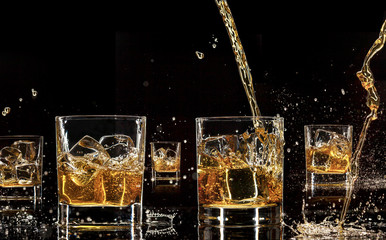 Alcohol drinks with splashes, isolated on black background