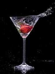 Fototapeten Martini-Getränk spritzt aus Glas auf schwarzem Hintergrund © Jag_cz